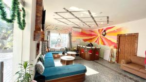 a living room with a blue couch and a colorful wall at GreenDay Escapes Rishikesh in Rishīkesh