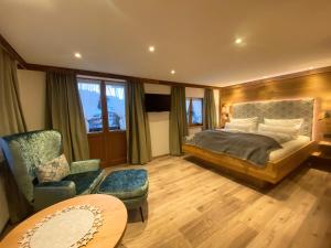 a bedroom with a bed and a chair and a table at Gatterhof in Riezlern