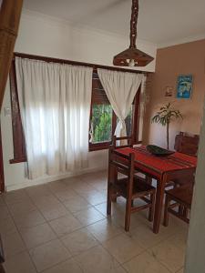 a dining room with a table and chairs and a window at Chalet Faro in Mar del Plata