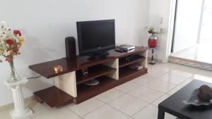 a living room with a television on a wooden entertainment center at Apto JACARANDA LAS AMERICAS in Playa de las Americas