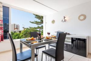 a dining room with a table and chairs and a window at Apto JACARANDA LAS AMERICAS in Playa de las Americas +6 photos