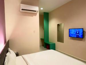 a room with a bed and a tv on the wall at Hotel Mirage PD in Port Dickson