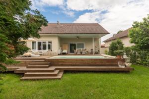 a backyard with a swimming pool and a house at Elegant Pool Bungalow - Vienna City Limit in Hennersdorf