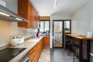 a large kitchen with wooden cabinets and counters at Albatros in Casares