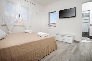 a bedroom with a bed and a flat screen tv at I Viaggi di Ki in Santa Teresa Gallura