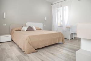 a white bedroom with a large bed with two pillows at I Viaggi di Ki in Santa Teresa Gallura +16 photos
