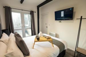 ein Schlafzimmer mit einem Bett und einem Fernseher an der Wand in der Unterkunft Charming Cottage Near Fields and Harry Potter Studios in Garston