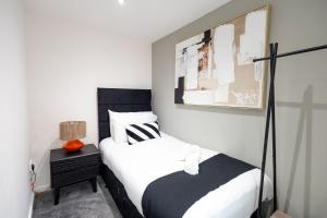 ein Schlafzimmer mit einem Bett und einer Lampe auf einem Nachttisch in der Unterkunft Charming Cottage Near Fields and Harry Potter Studios in Garston