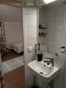 a bathroom with a sink and a mirror at Mäkelän Lomatuvat Bed and Breakfast in Hyytiälä