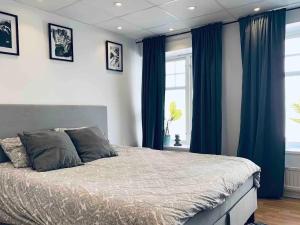 a bedroom with a large bed with blue curtains at Stunning Studio Old Town in Stockholm