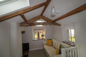 a living room with exposed beams and a couch at South View Cottage Dacre in Dacre