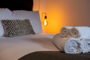 a pile of towels sitting on top of a bed at Watford 2-Bed Oasis - 20-min to London - Central in Watford