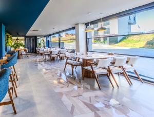 a restaurant with tables and chairs and large windows at Heaven Premium Hotel Restaurant & Airport Shuttle in Arnavutköy