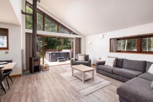 a living room with a couch and a table at Glentress Forest Cabins - Forest Holidays in Peebles