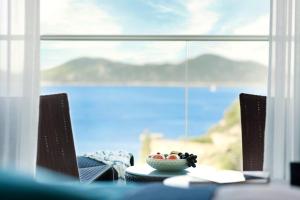 a table with a bowl of fruit in front of a window at Sun Gardens Dubrovnik in Dubrovnik