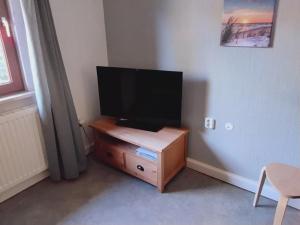 a flat screen tv sitting on top of a wooden cabinet at Hochwald appartement in Bad Sachsa