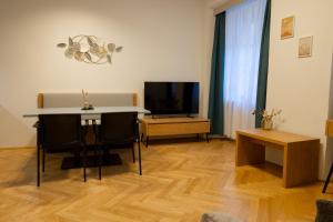 グラーツにあるAltstadtjuwel Färbergasse Grazのテーブルとテレビのあるリビングルーム