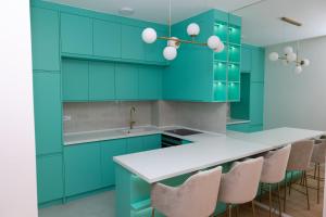a kitchen with blue cabinets and a white counter top at Sky Residence Barocco in Trebinje