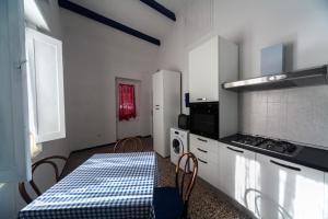 eine Küche mit einem Tisch, einem Herd und einer Mikrowelle in der Unterkunft Il Corallo E La Quercia Apartment in Villanova Monteleone