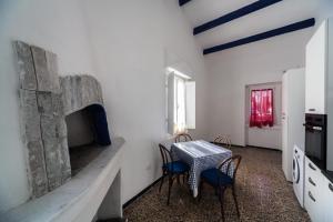 a dining room with a table and chairs and a fireplace at Il Corallo E La Quercia Apartment in Villanova Monteleone