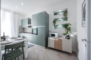 una cucina con tavolo e una cucina con forno a microonde di Train Station Deluxe 3 Bath a Bologna