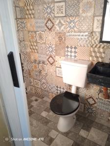 a bathroom with a toilet and a tiled wall at Lo de tina in Florencio Varela