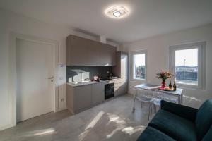 a kitchen with a couch and a table in a room at Residence - LA ROSA DEI VENTI in Ghedi
