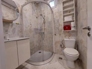 a bathroom with a shower and a toilet and a sink at Parrot House in Ericeira +32 photos