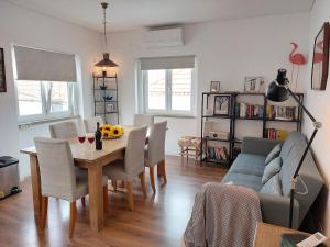 a living room with a table and chairs and a couch at Parrot House in Ericeira