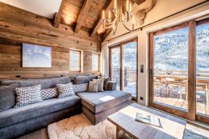 un soggiorno con un divano e un tavolo di Chalet Vallon, Méribel - by EMERALD STAY a Les Allues