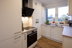 a kitchen with a sink and a stove at Penthouse Flensburg in Flensburg +8 photos