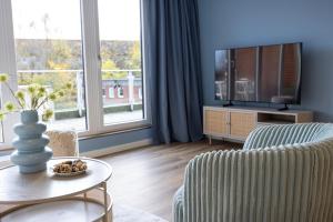 a living room with a tv and a couch and a table at Penthouse Flensburg in Flensburg