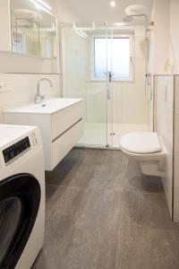 a white bathroom with a washing machine in it at Penthouse Flensburg in Flensburg