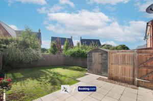 un jardín con una valla y una puerta de madera en Luxury House By AR Properties Short Lets & Serviced Accommodation Colchester, en Colchester