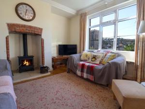 a living room with a couch and a fireplace at Barley Cottage in Seaton