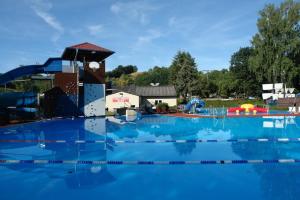 a large swimming pool with a water park in the background at Hinkelshof - als Ferienwohnung - Selbstversorgerküche & Aufenthaltsräume - Südeifel, Mullerthal, Vianden in Körperich