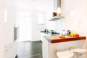 バーデン・バーデンにあるDeluxe Apartments LWP7のキッチン(白いキャビネット、木製カウンタートップ付)
