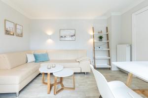 a living room with a white couch and a table at Ostsee-Bungalow 1 - Wicheldorfstr 72 - FERIENDOMIZIL HOLLICH in Grömitz