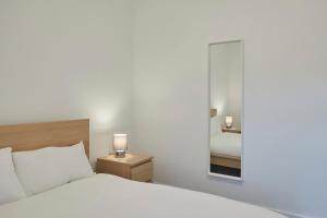 a bedroom with a white bed and a mirror at Zetland House Apt 4 in Loftus