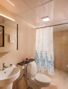 a bathroom with a white toilet and a sink at Blue Pavilion by Red Olive Electronic city in Bengaluru
