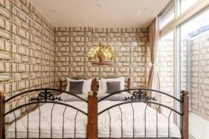 a bedroom with a bed and a brick wall at Blue Pavilion by Red Olive Electronic city in Bengaluru