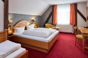 a hotel room with two beds and a table at Metzgereigasthof Rebstock in Münchweier +61 photos