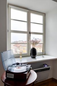 a record player on a table in front of two windows at Апартаменти на Площі ринок 3 in Lviv