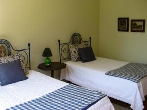 ヴィエイラ・ド・ミーニョにあるCasa Pala Luarのベッドルーム1室(ベッド2台、ランプ付きテーブル付)