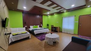 a room with two beds and a green wall at Bell Farms and Resorts in Munroe Island