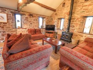 un soggiorno con 2 divani e una stufa a legna di Barn Owl Cottage a Penrith