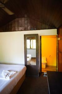 a bedroom with two beds and a door to a bathroom at Sameer beachfront Cottages in Canacona