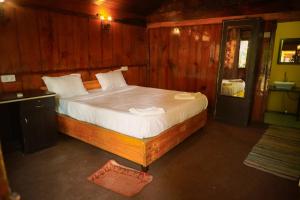 a bedroom with a large bed with white sheets at Sameer beachfront Cottages in Canacona