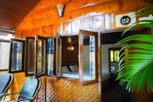 a room with a bedroom with a bed and windows at Sameer beachfront Cottages in Canacona