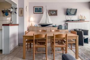 a dining room with a wooden table and chairs at Europe 0402 in Sint-Idesbald